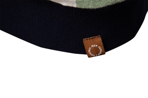 Close-up of navy knit polo shirt texture with a brown leather brand tag detail