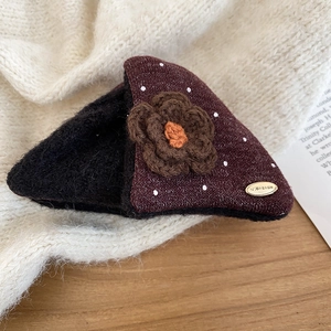 Detail of plush triangle hair claw with brown crochet flower and retro polka dot fabric