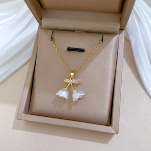 Detail of lily of the valley pendant with white petals and crystals in a jewelry box