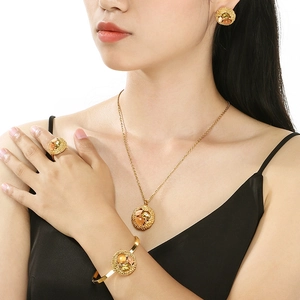 Model wearing a gold jewelry set with pink and yellow stones in a round镂空 design