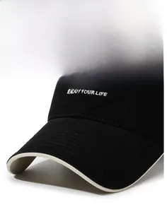 Detail of black cotton baseball cap with white embroidered letters and contrast brim edge