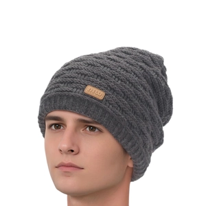 Detail of dark grey knit beanie featuring a brown leather logo patch for winter warmth