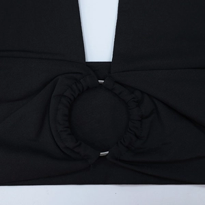 Détail rapproché de l'anneau métallique reliant le tissu noir froncé du haut court