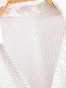 Close-up of thin black vertical stripes on white cotton shirt fabric texture
