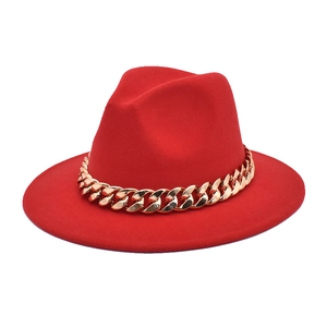 Detailed view of red wool jazz fedora hat featuring a chunky decorative gold chain