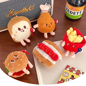 Close-up of food-themed plush keychains with burger and fries on a wooden table