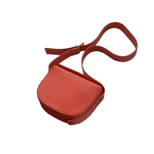 Classic red PU leather saddle bag with adjustable shoulder strap on white background