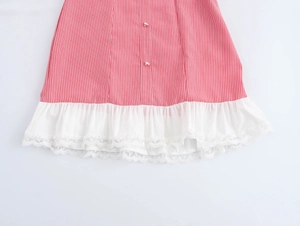 Detail of red striped dress featuring white ruffle hem and delicate lace trim