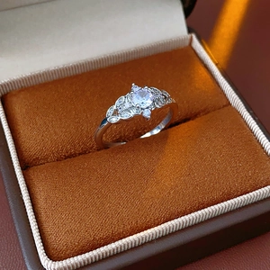 Detail of zircon crown ring with leaf design on a brown velvet jewelry box