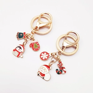 Detailed view of Christmas keychains with Santa and Penguin enamel charms in gold metal