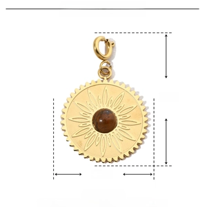 Dettaglio del ciondolo a sole in acciaio dorato 27x17mm con intarsio in pietra naturale marrone
