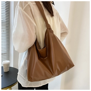 Brown PU leather tote bag details showing soft texture and large capacity on shoulder
