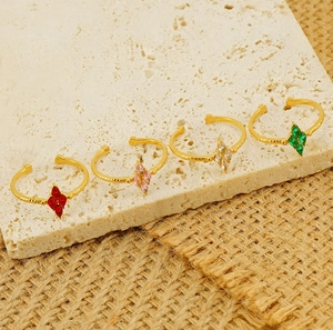 Detail of four gold-plated adjustable rings with colorful diamond-shaped zircons on stone