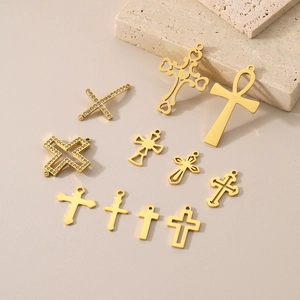 Flat lay of 10 assorted 18K gold-plated stainless steel hollow cross charms for DIY jewelry