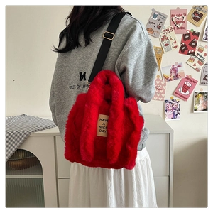 Red plush tote bag with adjustable strap and HAVE A NICE DAY label on the side