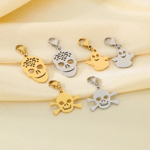 Detailed view of skull and ghost steel pendants with lobster clasps on silk background