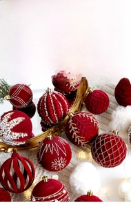 Close-up of deep red flocked Christmas balls with pearl inlay and golden glitter details