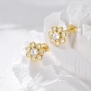 Macro shot of S925 sterling silver gold flower stud earrings with sparkling cubic zirconia