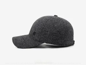 Detail view of thick grey wool blend cap fabric with a black G letter emblem on side