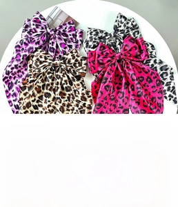 Detail view of leopard print bow hair clips with long ribbons in four colors
