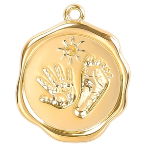 Golden stainless steel circular pendant with embossed handprint, footprint and sun patterns