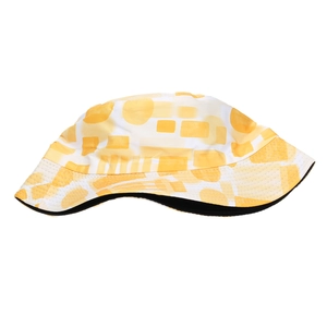 Detail of outdoor bucket hat featuring yellow geometric prints and a wide protective brim