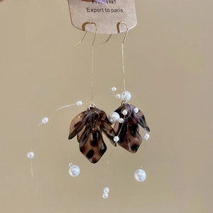 Detail of vintage leopard resin petals with white pearls and gold tassel ear hooks