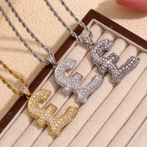 Close-up of pound sign pendants set with clear crystals on twist chains in a jewelry tray