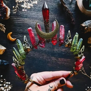 Handmade red and green crystal moon crown headband with skull detail on wooden desk