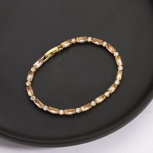 Elegante bracciale dorato con gemme champagne e pavé di cristalli di zircone scintillanti
