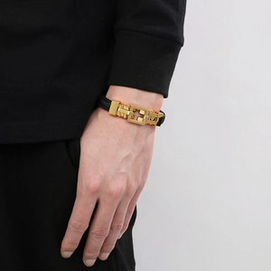 Close-up of men's black braided leather bracelet with golden square buckle on wrist