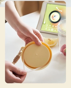 Detailed view of the yellow leakproof lid with silicone seal and woven carrying strap