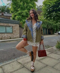 Manteau rétro à col à carreaux avec robe florale et sac en cuir en décor urbain