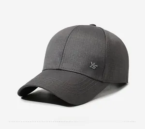 Détail d'une casquette de baseball gris foncé avec logo YS en métal et texture sergé
