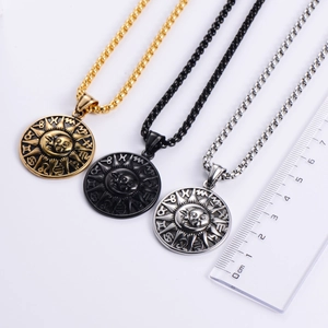 Gros plan des pendentifs zodiaque soleil et lune avec règle pour échelle de taille réelle