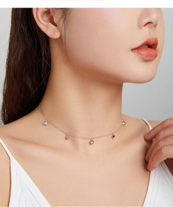 Detail of s925 silver shell necklace with purple and blue zircon stones on a model's neck