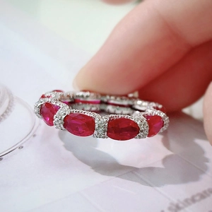 Close-up of a silver ring featuring a vibrant red ruby and sparkling diamonds