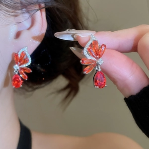 Macro view of orange butterfly drop earrings with shimmering zircon crystal wings