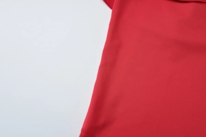 Makroaufnahme der roten Stofftextur und der Rüschenkante des Sommer-Strandkleids