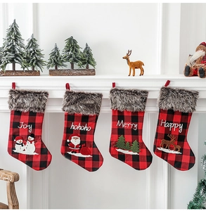 Détail de chaussettes de Noël à carreaux rouges avec revers en fourrure et broderies