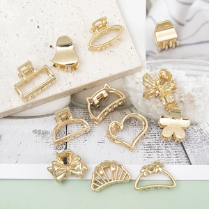Close-up of assorted mini gold alloy hair claws in heart and butterfly shapes