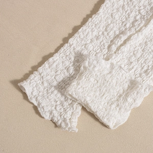 Detailed macro view of white 3D bubble textured fabric with soft pleats and elastic structure