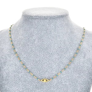 Détail du collier œil maléfique doré avec perles bleu lapis sur buste en velours gris