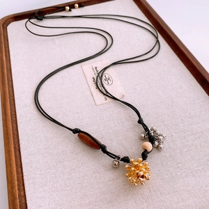 Détail du collier vintage avec pendentif grappe, perles en bois et petites cloches