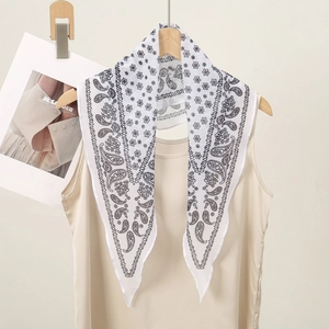 Detail showing white chiffon scarf with black paisley pattern tied on a vest collar