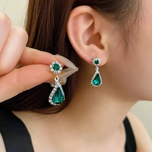 Vintage silver earrings with green water drop gems and crystal accents worn by model