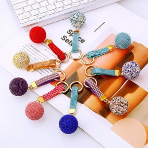 Close-up of sparkling rhinestone ball keychains in multiple vibrant colors with metal clasps