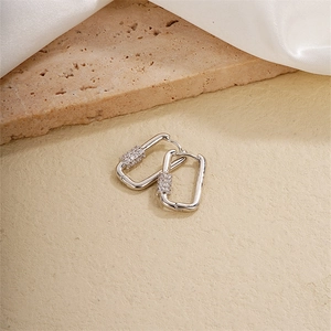 Silver geometric U-shaped earrings with pavé cubic zirconia on textured background