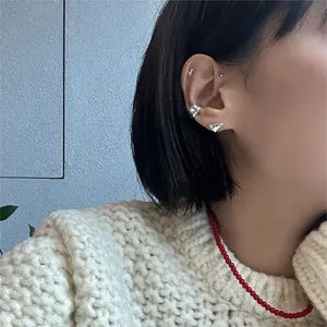 Detail of 925 sterling silver heart earrings and ear cuffs on a model side profile