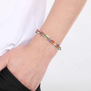 Dettaglio del bracciale a catena cubana in smalto colorato e finitura dorata sul polso